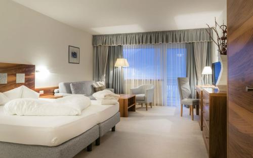a hotel room with two beds and a desk at Residenze Mathilda in Silandro