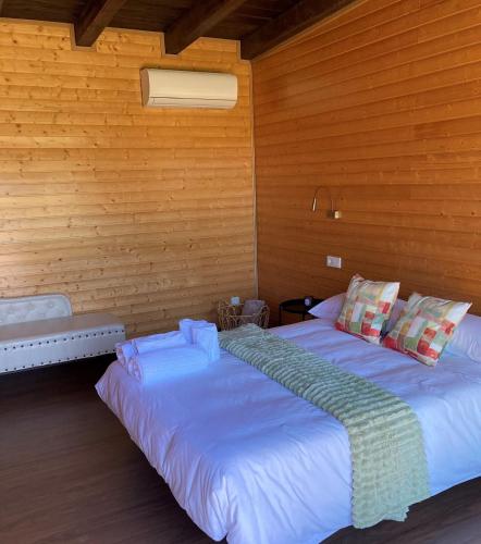 a bedroom with two beds in a wooden wall at A Quinta de Bouzas in Mazaricos