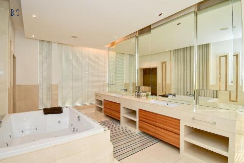 a large bathroom with a tub and a large mirror at Luxury 7BR Villa with Premium Amenities - Private Cinema, Pool and Gym -Emirates Hills in Dubai