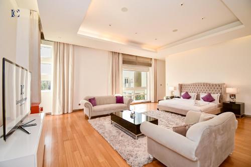 a living room with white furniture and a tv at Luxury 7BR Villa with Premium Amenities - Private Cinema, Pool and Gym -Emirates Hills in Dubai