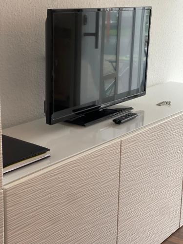 a flat screen tv sitting on top of a dresser at Ruhige Ferienwohnung in Heskem - Berthold Apartments 
