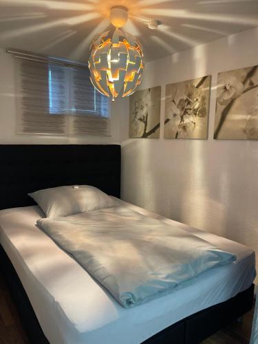 a bedroom with a bed and a chandelier at Ruhige Ferienwohnung in Heskem - Berthold Apartments in Heskem
