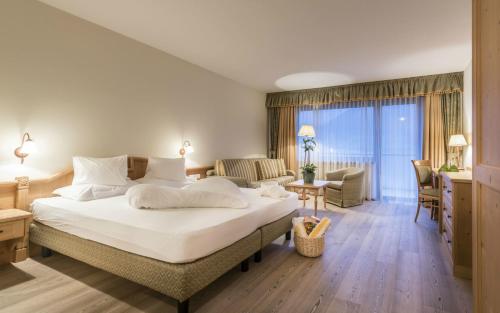 a hotel room with a large bed and a living room at Residenze Mathilda in Silandro
