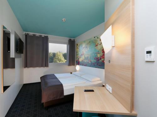 ein Hotelzimmer mit einem Bett und einem Tisch in der Unterkunft B&B Hotel Potsdam in Potsdam