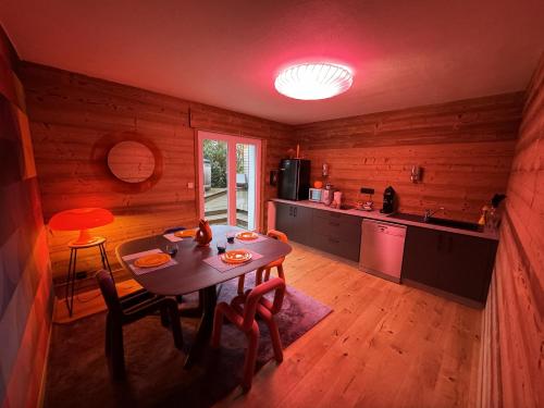 une cuisine avec une table et des chaises dans une pièce dans l'établissement L'ANNEXE, à Saint-Étienne-lès-Remiremont