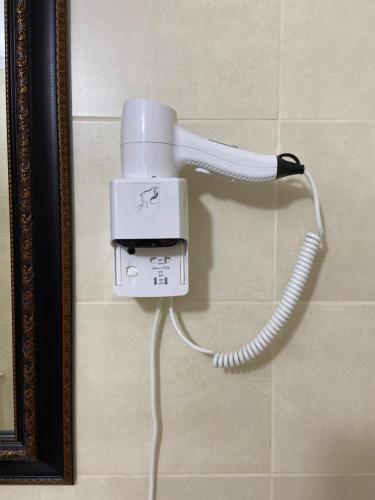 a white blow dryer hanging on a wall at ЭкоДом in Bilhorod-Dnistrovsʼkyy