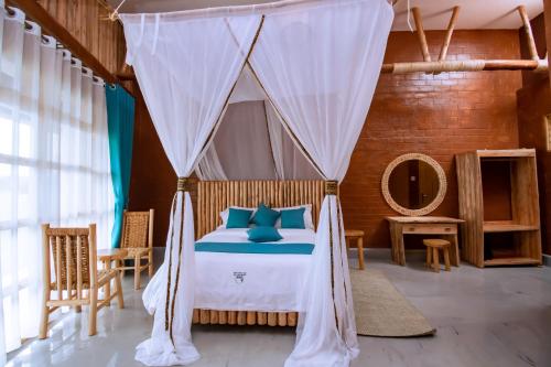 Schlafzimmer mit einem Bett mit Moskitonetz in der Unterkunft Mara Safari Lodge Kidepo 