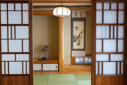 熊本的住宿－合い宿 くまもと，一间设有两扇门和一盏吊灯的房间