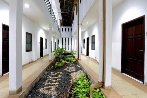 a corridor of a building with a plant at Jambuluwuk Residence Menteng in Jakarta