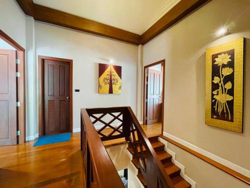 a room with a staircase and paintings on the walls at Baan Natcha Villa in Pattaya Central