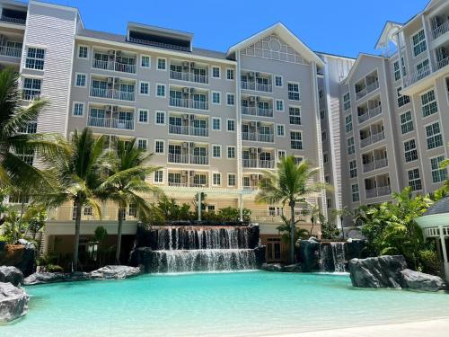 a pool with a waterfall in front of a building at Pattaya Grand florida Beach 36 in Na Jomtien