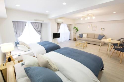 a bedroom with two beds and a living room at PALAIS GRACE 301 in Tokyo