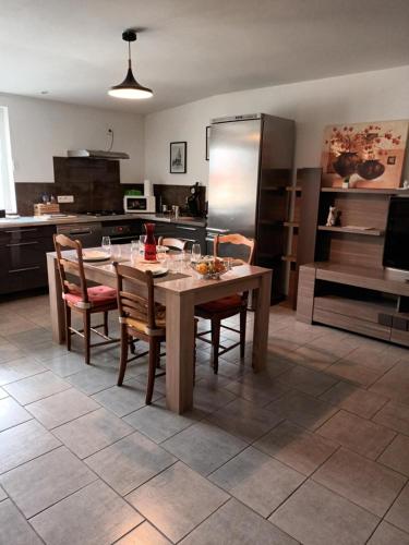 eine Küche mit einem Tisch mit Stühlen und einem Kühlschrank in der Unterkunft Chemin du Grand Pré in Gripport