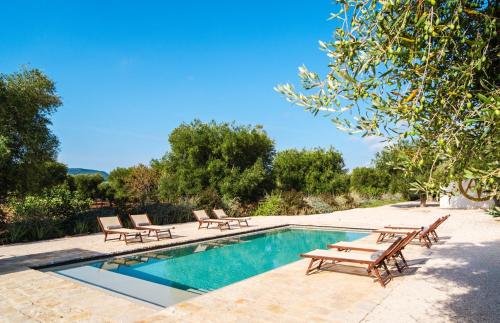 een zwembad met ligstoelen en een tafel bij Tenuta Fonte in Ostuni