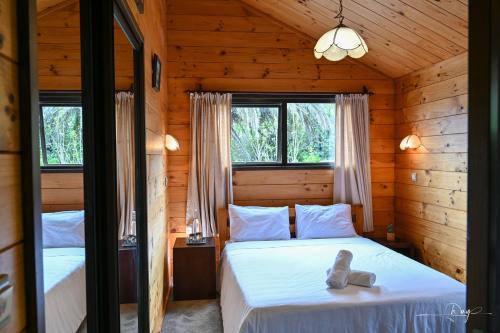 a bedroom with two beds in a log cabin at Auckland Beachview Homestay with free Netflix, Parking in Auckland