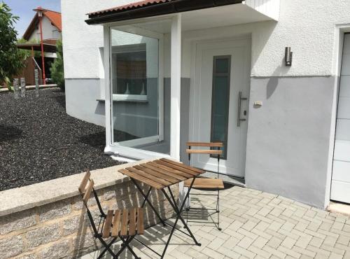 a picnic table and two chairs in front of a house at Ruhige Ferienwohnung in Heskem - Berthold Apartments 