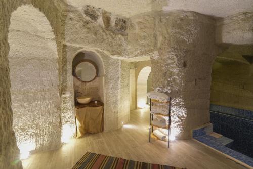 a room with a stone wall with a ladder in it at My Cave Suites in Nevsehir