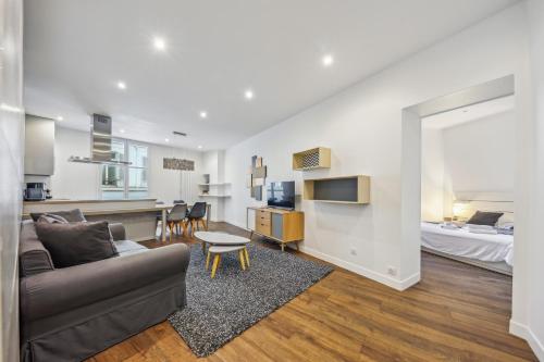 un salon avec un canapé et un lit dans l'établissement Appartement charmant et lumineux en plein cœur de Paris, à Paris