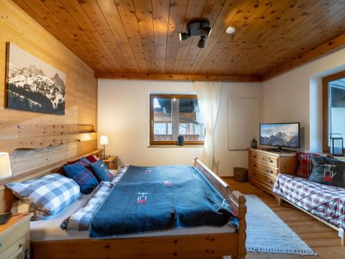 a bedroom with a bed and a couch in a room at Chalet Kitzalm in Oberndorf in Tirol
