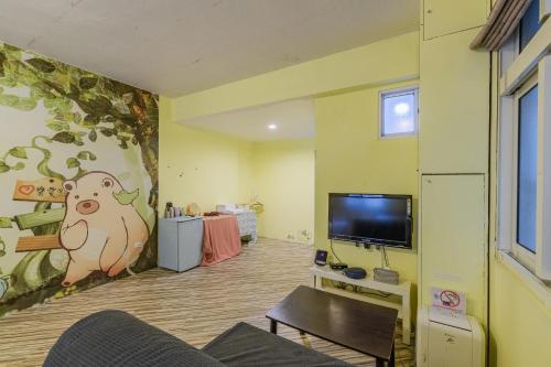 a living room with a couch and a tv at Fengjia Love I Hostel in Taichung