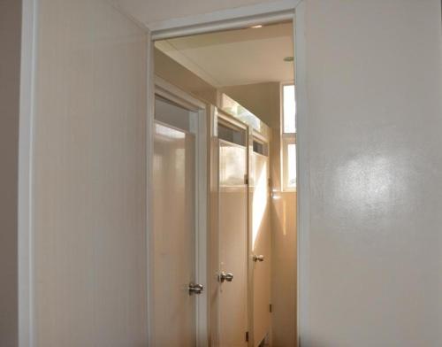 a hallway with a mirror and a door in a room at Harimariz Dormitory Official in Dumaguete