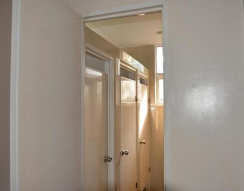 a hallway with a mirror and a door in a room at Harimariz Dormitory Hotel Official in Dumaguete