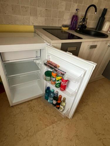 an open refrigerator in a kitchen next to a sink at Apartament Ingrid in Piatra Neamţ