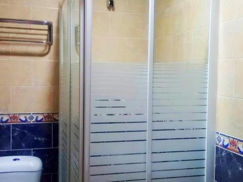 y baño con ducha y puerta de cristal. en Apartamento Trafalgar con aire familias y parejas, en Conil de la Frontera