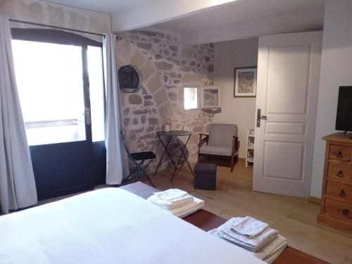 1 dormitorio con cama, mesa y ventana en Le clos de l'Olivelle, en Gallargues-le-Montueux