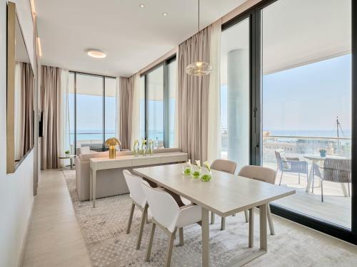 a dining room with a table and a living room at Arabella Beach Hotel Kuwait Vignette Collection, an IHG Hotel in Kuwait
