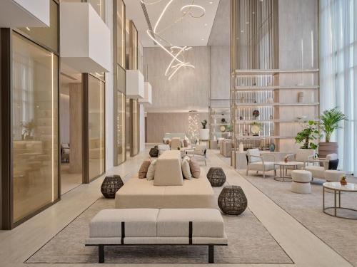 een hotellobby met banken, tafels en stoelen bij Arabella Beach Hotel Kuwait Vignette Collection, an IHG Hotel in Koeweit