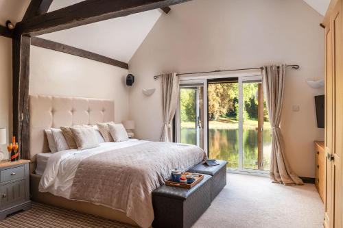 a bedroom with a large bed and a large window at Lake House in Brecon