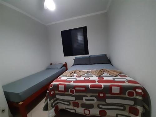 een slaapkamer met een bed en een flatscreen-tv bij LA05-Bertioga, Próximo ao SESC, Riviera, Vista Linda, Indaiá in Bertioga