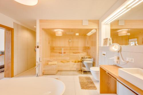 La salle de bains est pourvue d'une baignoire, de toilettes et d'un lavabo. dans l'établissement Luxus Chalet - Zentral - Poolblick mit Sauna, à Seefeld in Tirol