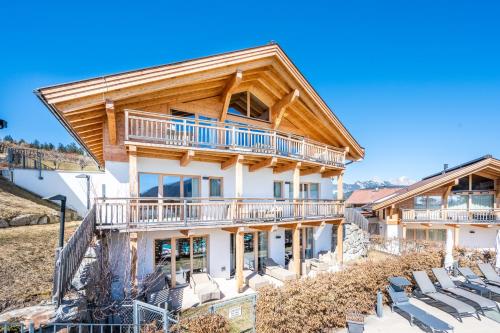 Cette grande maison en rondins est entourée d'une terrasse. dans l'établissement Luxus Chalet - Zentral - Poolblick mit Sauna, à Seefeld in Tirol