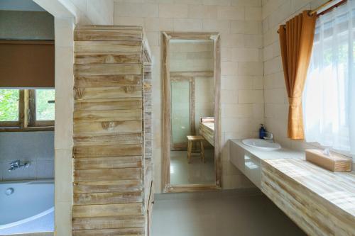 La salle de bains est pourvue d'une baignoire et d'un lavabo. dans l'établissement Agaru Villa Uluwatu by The Lavana, à Uluwatu