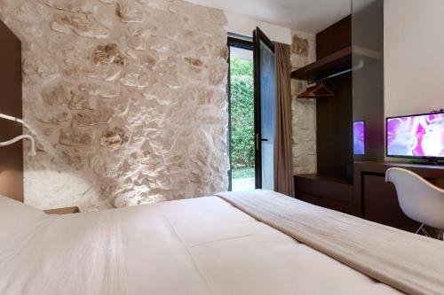 a hotel room with a bed and a tv at Villa Boscarino Boutique Hotel & Spa in Ragusa