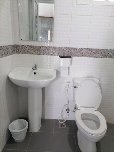 a white bathroom with a toilet and a sink at Guesthouse Phuket Airport in Ban Bo Han