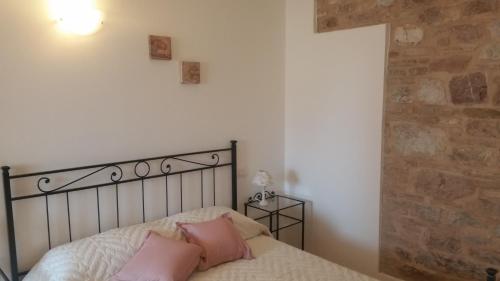 Un dormitorio con una cama con almohadas rosas. en B&B Le Rose, en Spello