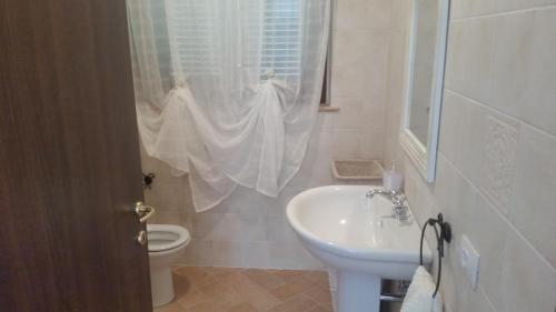 a white bathroom with a sink and a toilet at B&B Le Rose in Spello