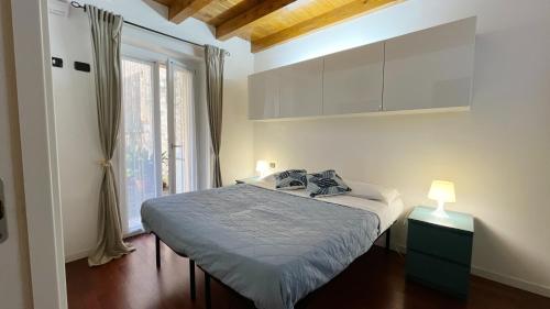 a bedroom with a bed and a large window at La casa di Giò - Affitti Brevi Italia in Lecco