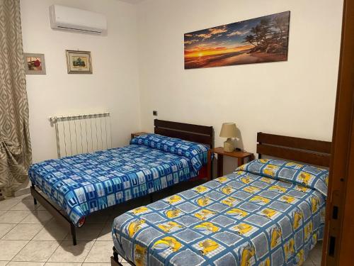 um quarto com duas camas e uma foto na parede em Casa relax em San Donato Val di Comino