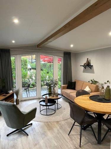 a living room with a couch and a table at SERENDIPITY - nature in luxury in Beekbergen