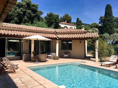 une piscine devant une maison dans l'établissement VILLA 4* avec PISCINE dans le bas du village de BORMES les MIMOSAS, à Bormes-les-Mimosas