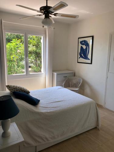 une chambre avec un lit et un ventilateur de plafond dans l'établissement VILLA 4* avec PISCINE dans le bas du village de BORMES les MIMOSAS, à Bormes-les-Mimosas