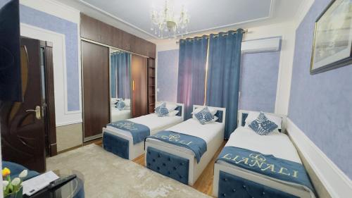 a room with three beds and a chandelier at LIANALI HOTEL in Bukhara