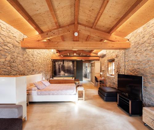 a bedroom with a bed and a stone wall at El Rebastral - Mas Vinyoles Natura in Sant Pere de Torelló