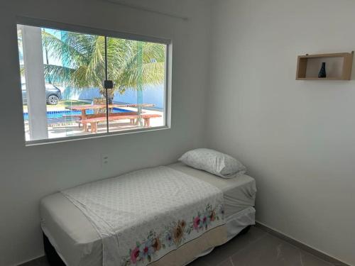 a bedroom with a bed and a window at Beachhouse in Barra do Sirinhaém in Barra do Sirinhaém