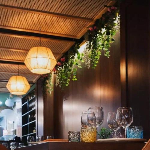 a table with wine glasses and lights on a wall at room 34- with kitchenette at the new Olo Living by SF Homes in Paceville