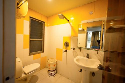 a bathroom with a sink and a toilet and a mirror at Family Hotel Opera Near IGI Airport in New Delhi